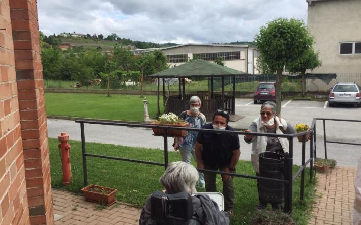 Familiari in visita ad una ospite in giardino a inizio maggio